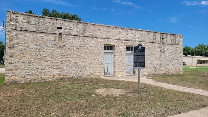 Front of the limestone Lampasas Colored School with its Texas Historical Commission marker on a sunny day