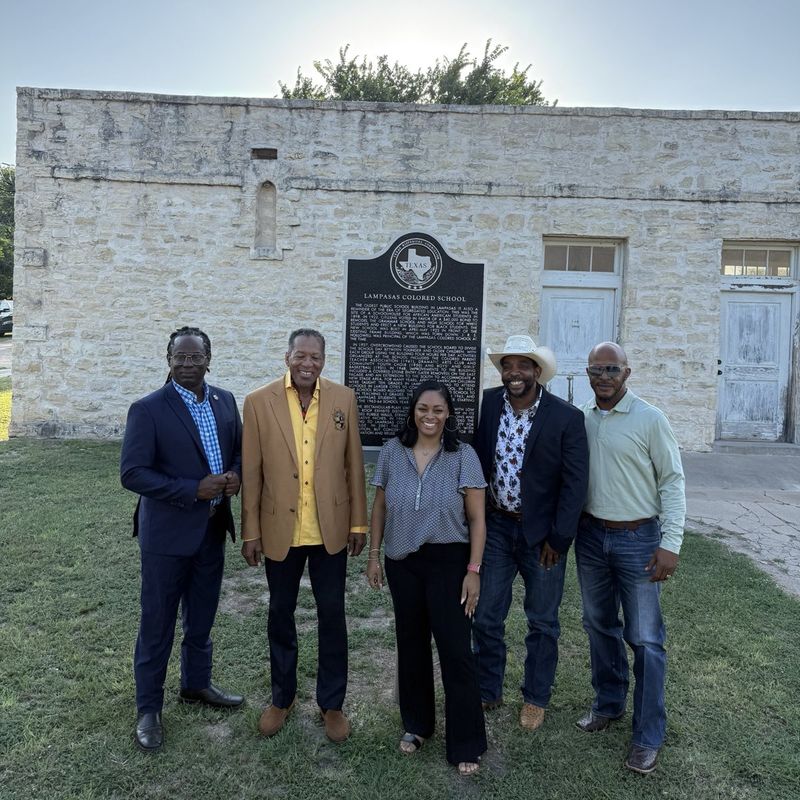 The five members of the LCS board of directors standing in front of the Lampasas Colored School and its marker